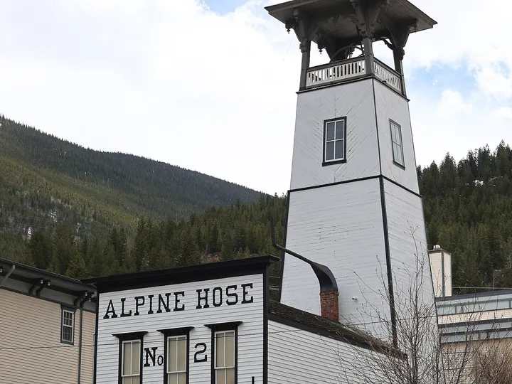 The white Alpine Hose No. 2 firehouse and bell tower in Georgetown, signed as the Georgetown Firefighting Museum, in May 2024