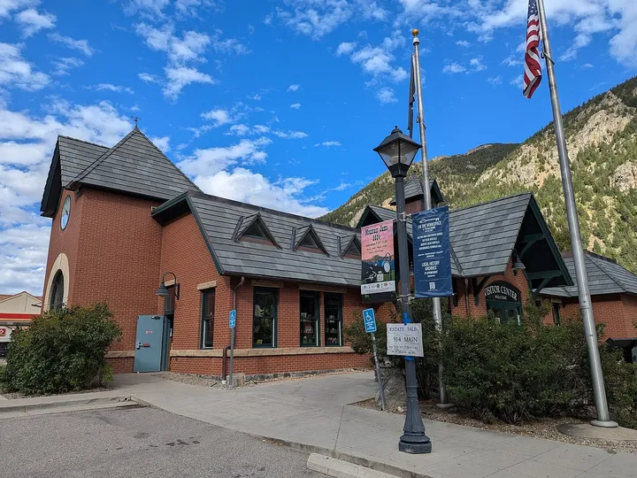 The red-brick Gateway Visitor Center in Georgetown, with its clock tower and Visitor Center sign below the mountainside, in September 2024