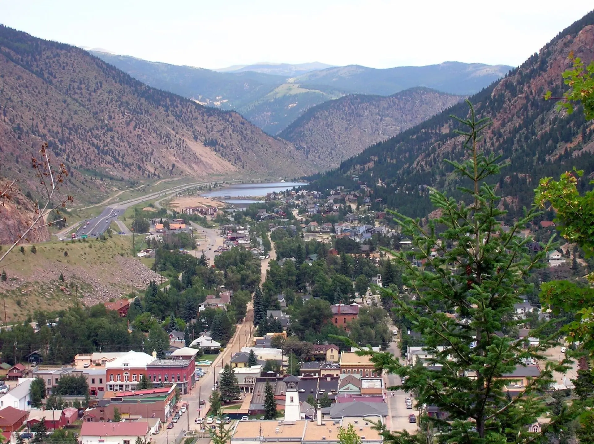 Looking north over Georgetown from the hillside: the town fills the valley floor, with Georgetown Lake and Interstate 70 beyond between steep mountainsides