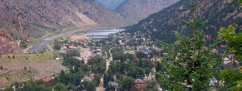 Looking north over Georgetown from the hillside: the town fills the valley floor, with Georgetown Lake and Interstate 70 beyond between steep mountainsides