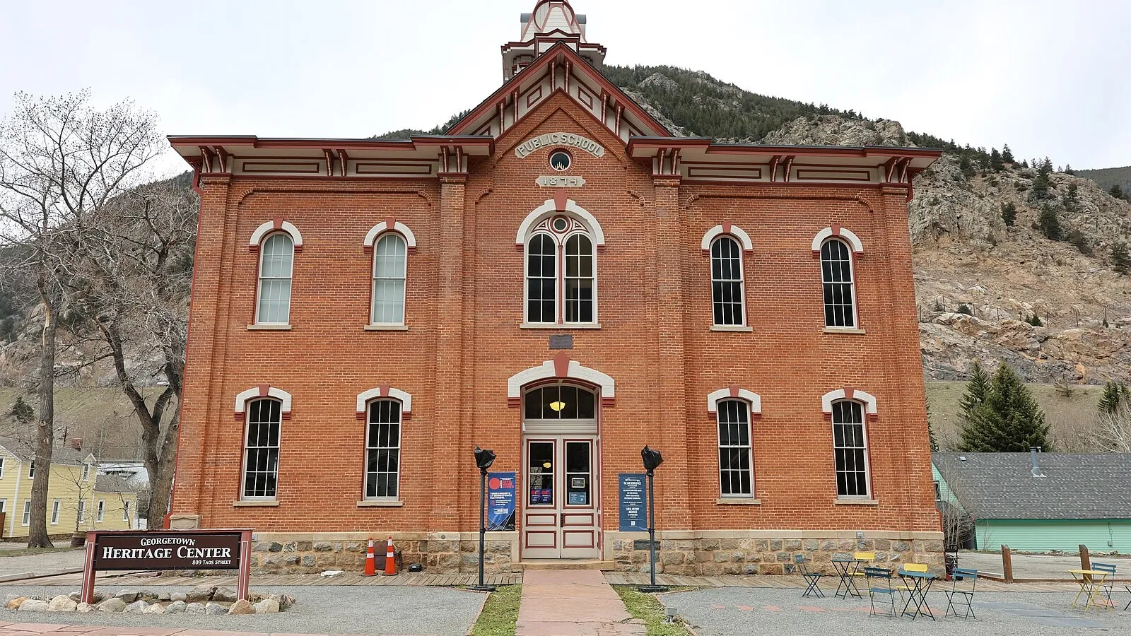 The red-brick 1874 Georgetown public school on Taos Street, now the Old School, with its earlier Georgetown Heritage Center sign out front, in May 2024